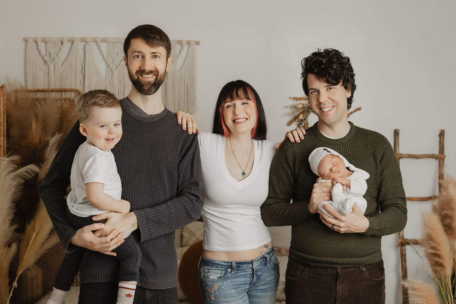 Family portrait session showing joyful interactions with their baby in a neutral studio setting.