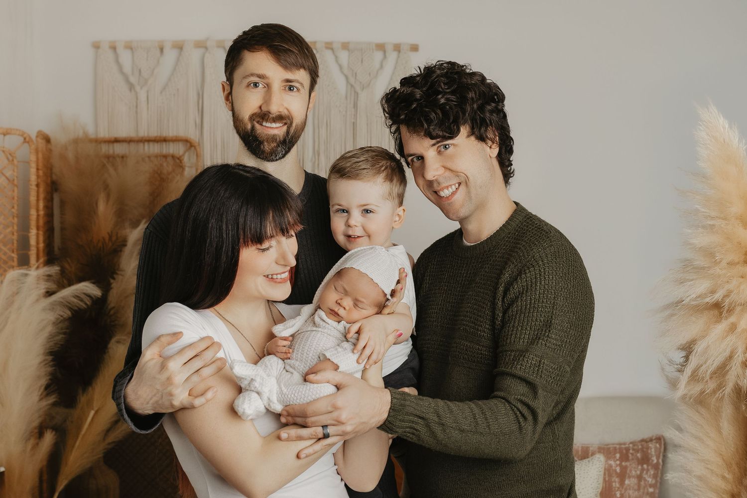 Candid family photoshoot featuring natural moments with a baby against a light backdrop.