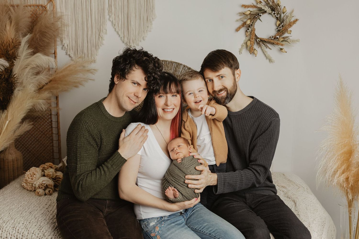 Modern family portrait series capturing playful interactions in a minimalist studio setting.