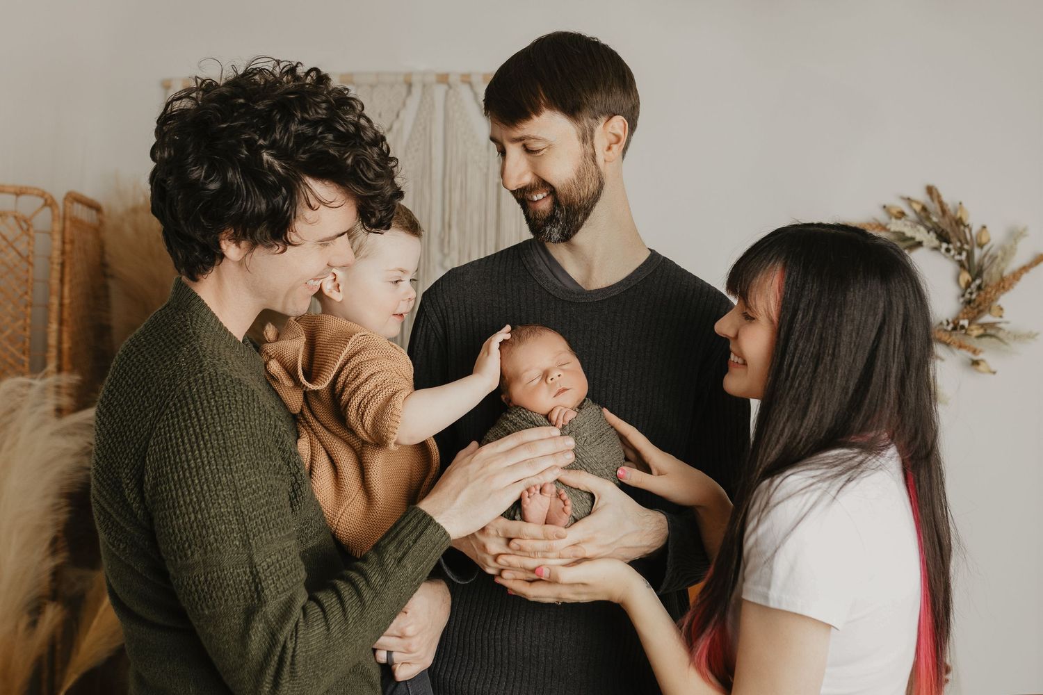 Artistic family photos showing intimate moments against a neutral background with natural lighting.