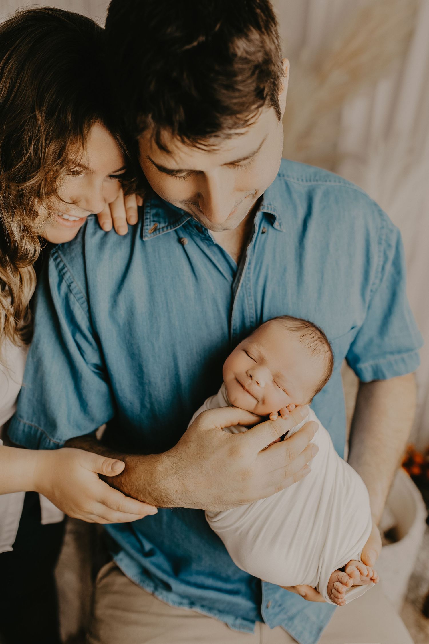 Intimate newborn photography session showing tender moments in soft natural light.