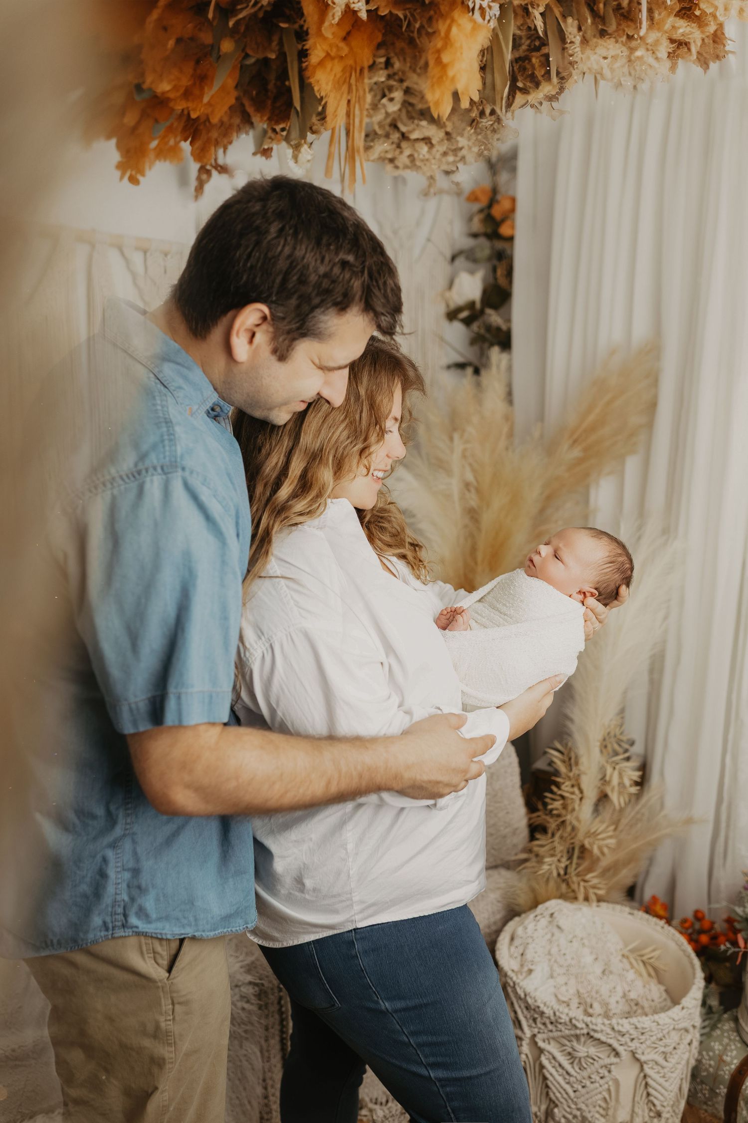 Family photo session with autumn decor and dried flowers in warm tones.