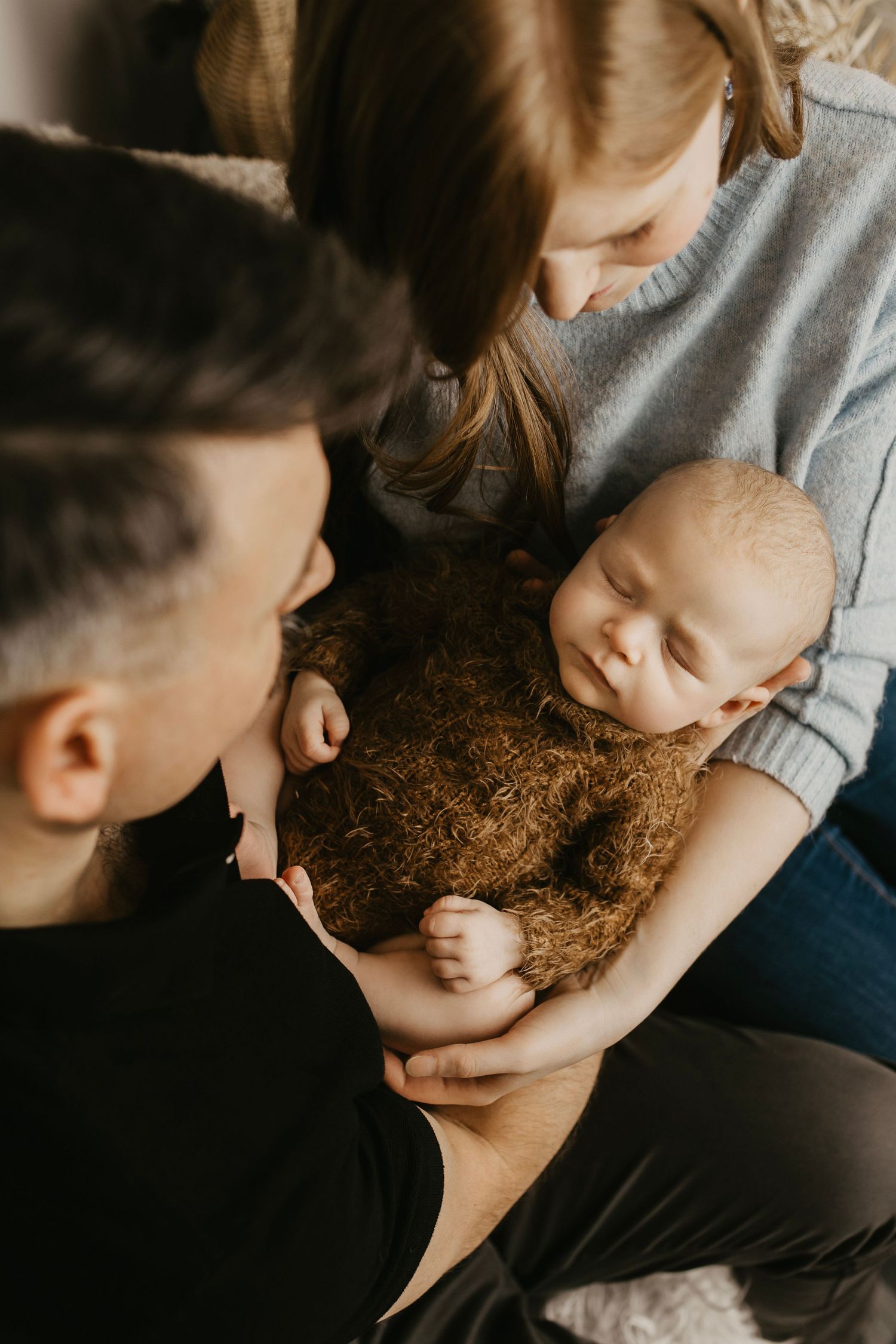 Intimate family portrait series showing tender moments against neutral backdrop with boho decor.