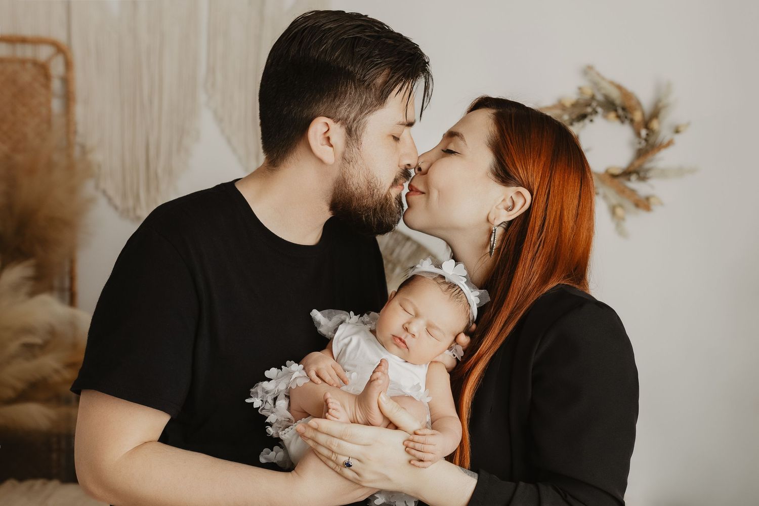 Moody family portraits showing intimate moments with a newborn in neutral tones.