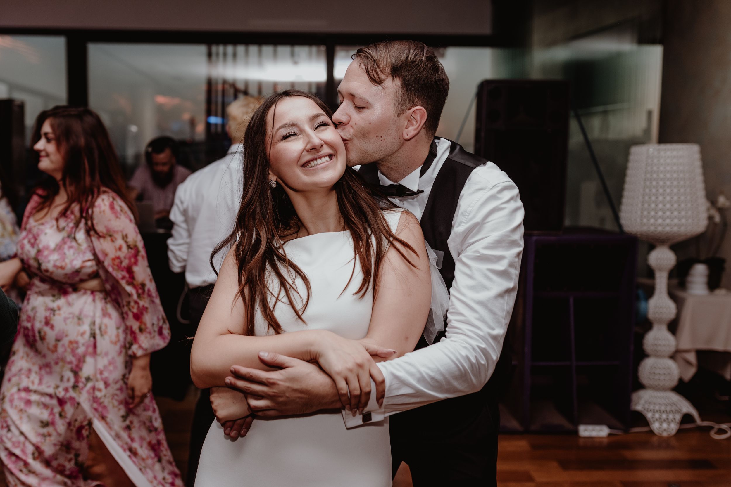 Bride and groom laughing and dancing on the dance floor of Bon Apetit restaurant captured in wedding photography.