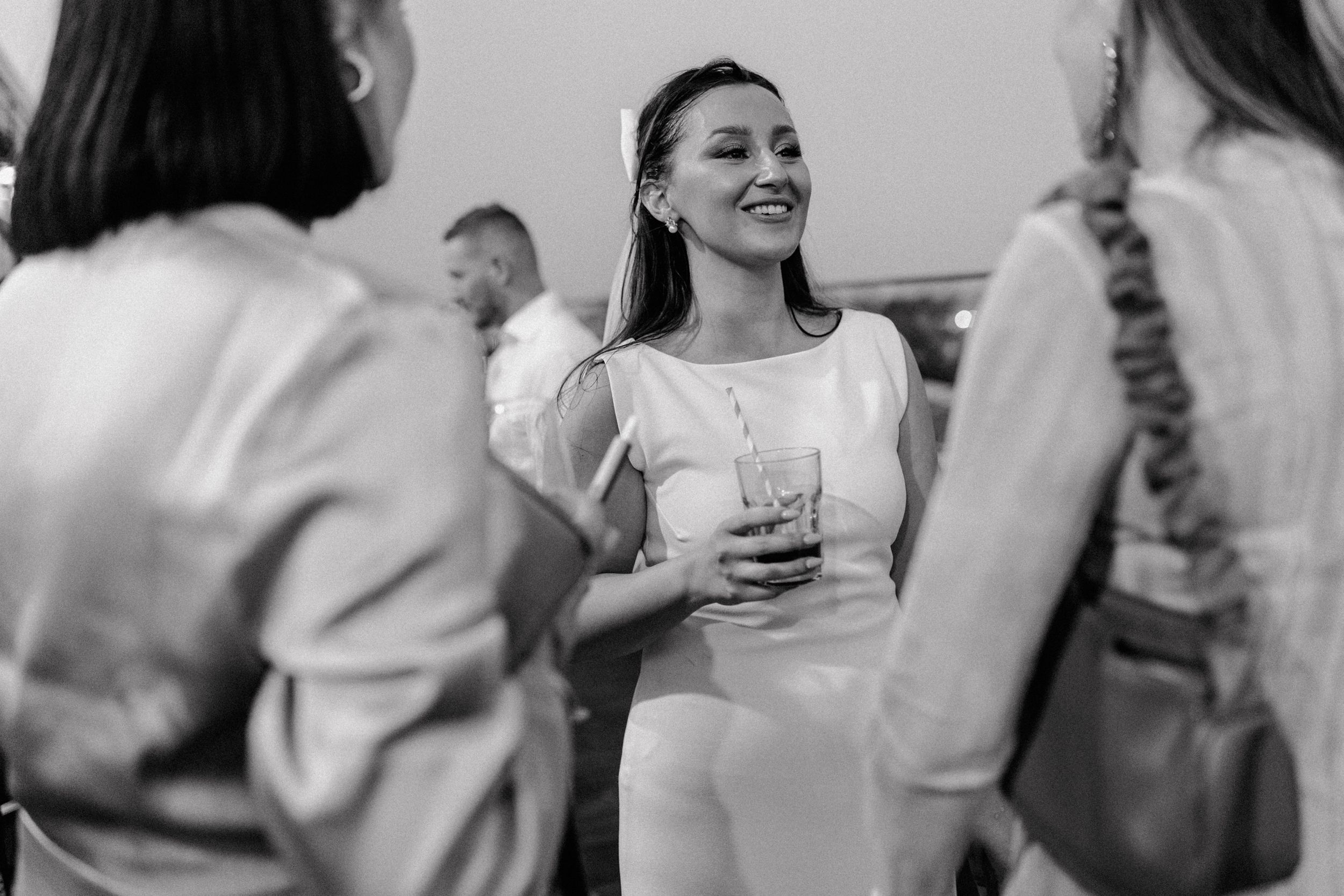Happy wedding guests captured in a candid moment, sipping cocktails and enjoying the ambiance.
