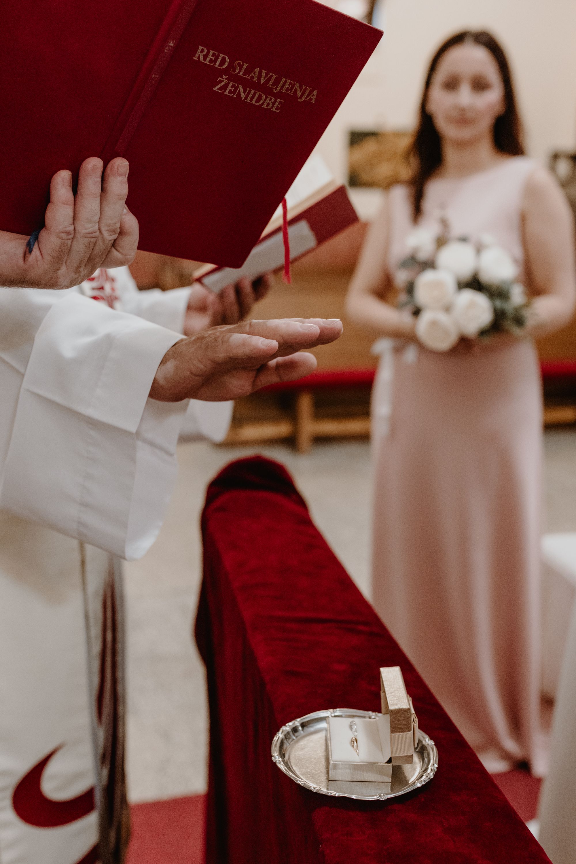 Priest praying over wedding rings in St.Petar Church in Zagreb during ceremony captured trough wedding photography.
