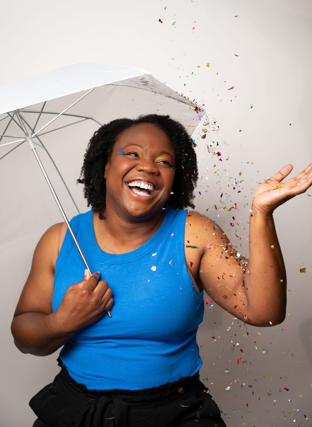 Festive portrait series with rainbow party decorations and blue top.