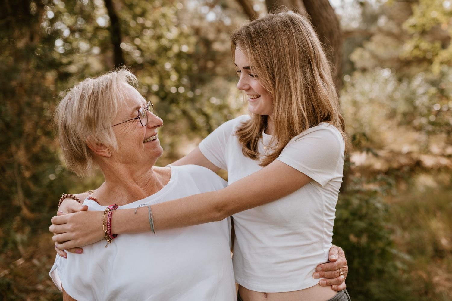 Jong meisje met haar oma in het bos. Prachtig zonnige dag