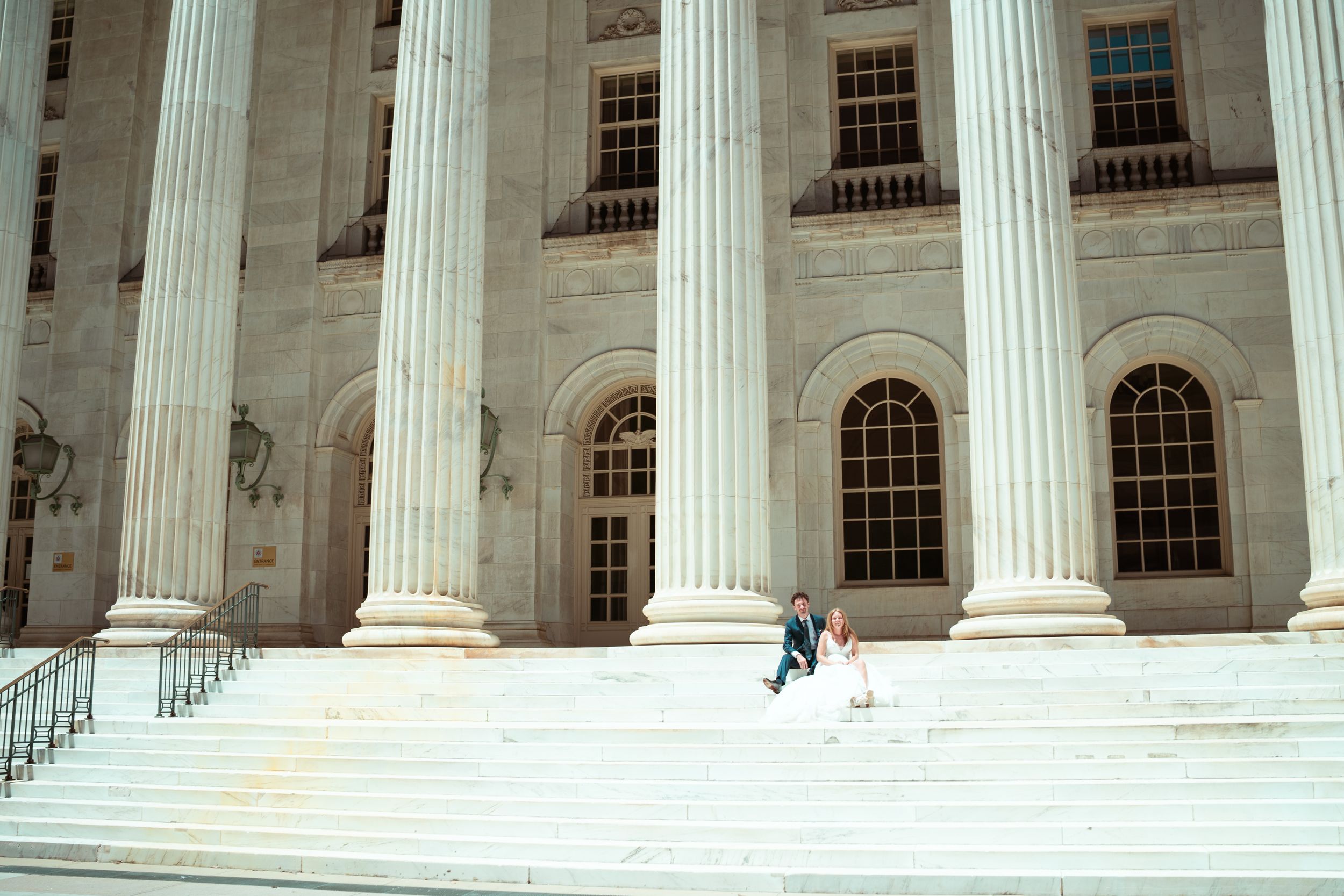 Majestic white marble columns line the exterior of a grand government or institutional building.
