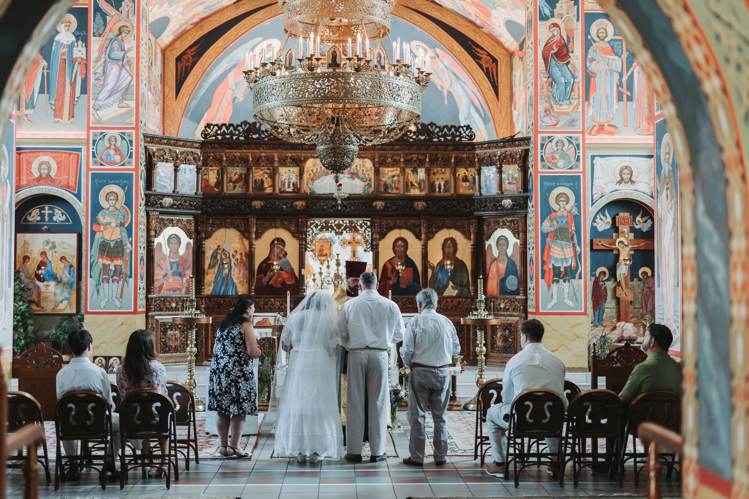 Panoramic view of an Orthodox church interior with detailed religious murals and iconostasis.