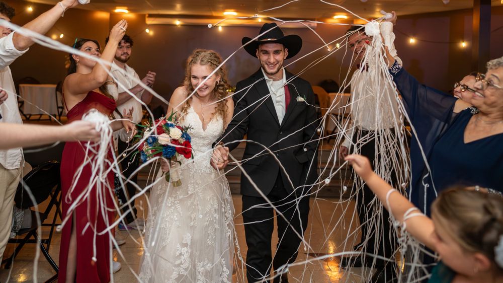 Wedding celebration indoors with guests holding sparklers creating light trails.