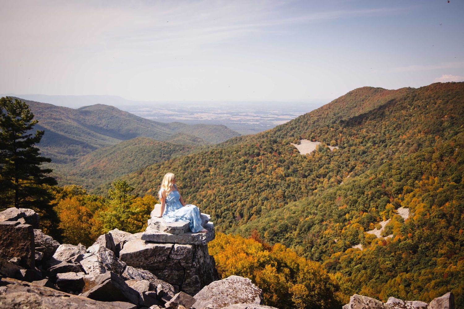 Panoramic view of mountain ranges and valleys covered in autumn foliage.