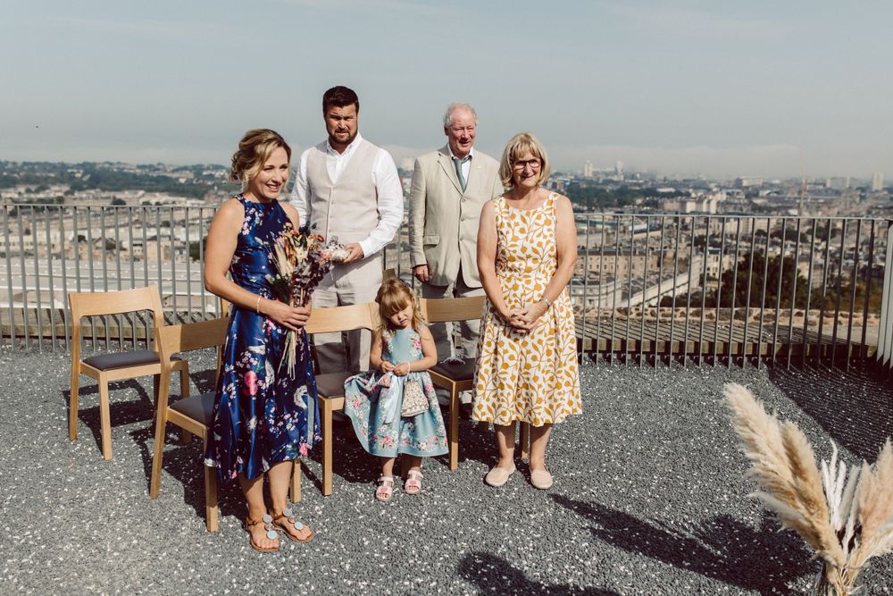 Wedding guests gathered on a rooftop terrace for outdoor celebration.