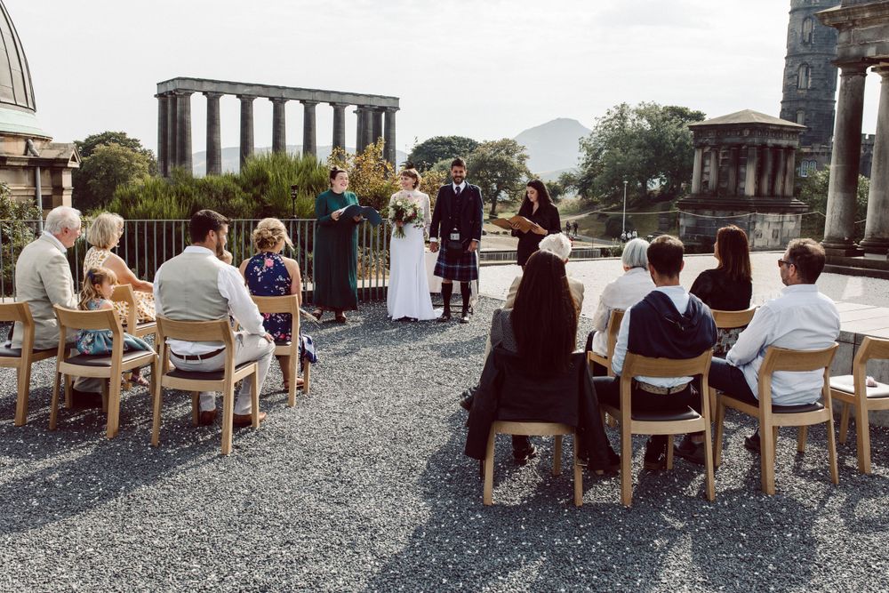 Rows of chairs set up for an outdoor event with classical columns in the background.