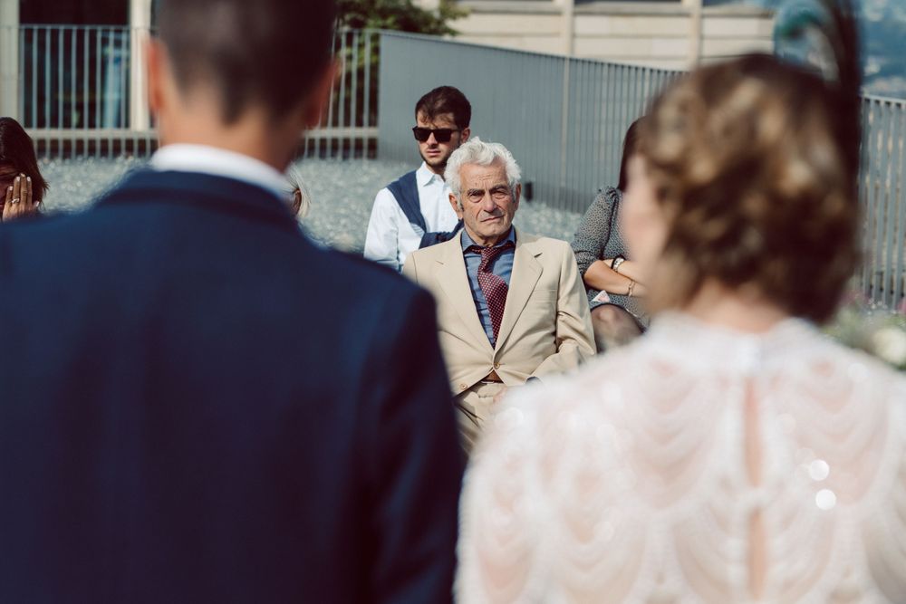 Wedding guests seated in outdoor ceremony space with mountain backdrop.