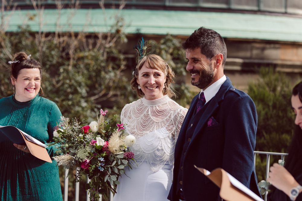 Outdoor wedding ceremony with floral arrangements and guests in attendance.