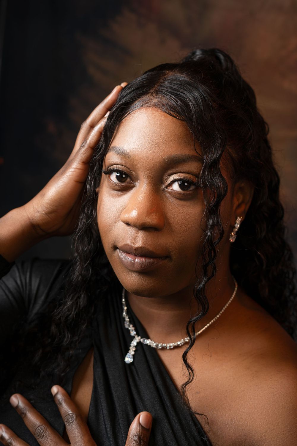Close-up beauty portrait with jewelry and dramatic studio lighting.