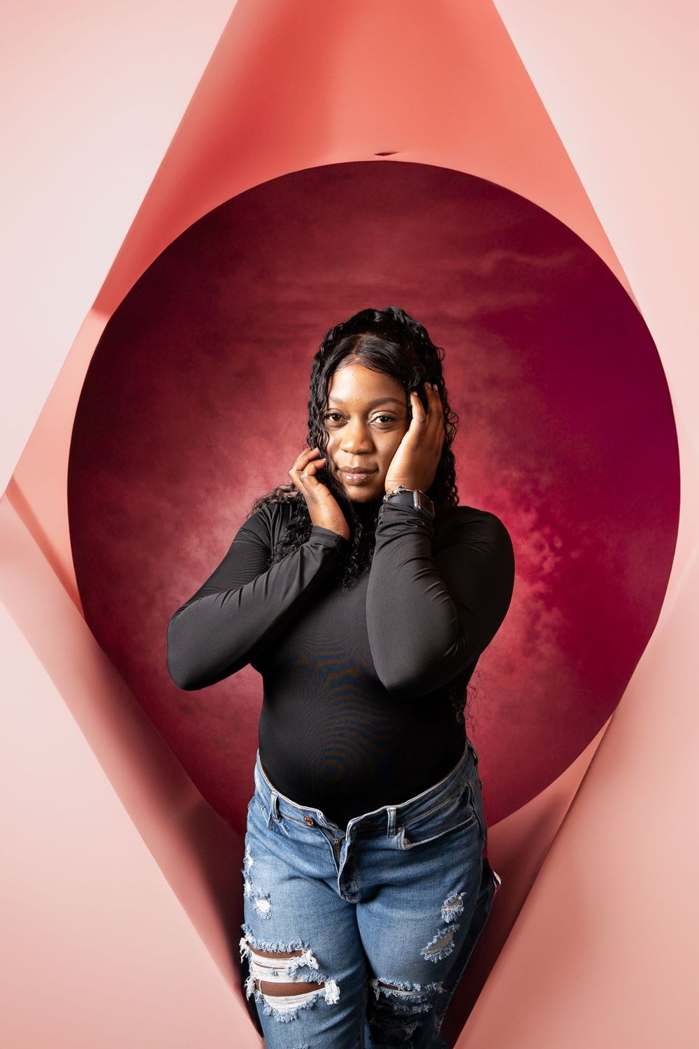 Creative portrait through pink geometric frame against burgundy background.