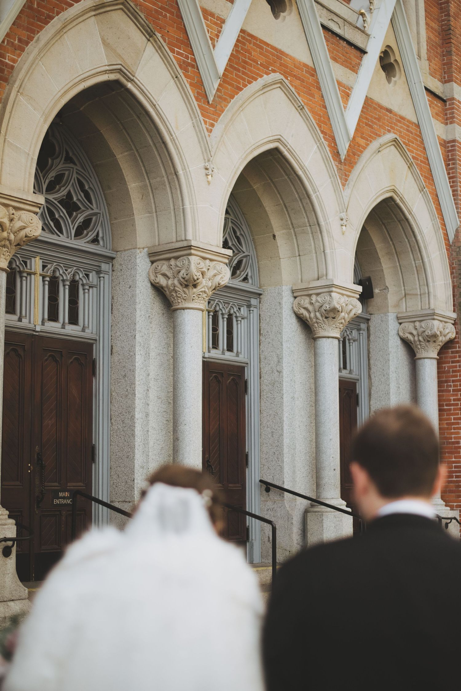 bride and groom walking towards the front doors of st andrews cathedral in victoria bc