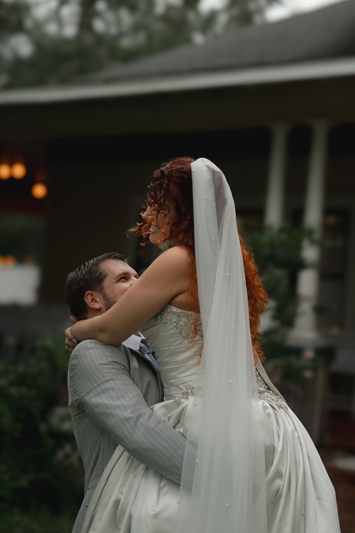 Romantic bride and groom embrace during their wedding dance with beautiful evening lighting.
