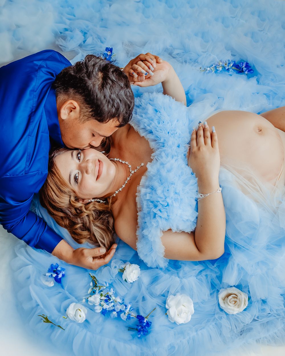 Intimate maternity portrait with blue and white floral styling.