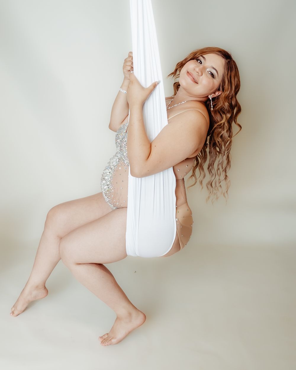 Artistic maternity photo with white aerial silk.