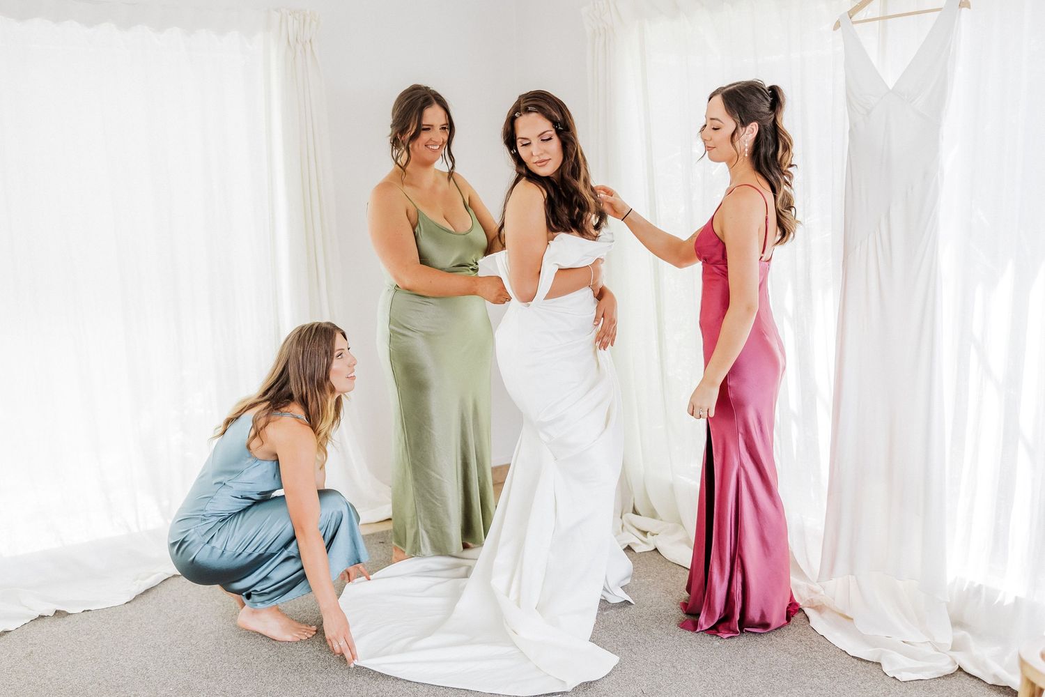 Bride with her bride's maids helping her dress