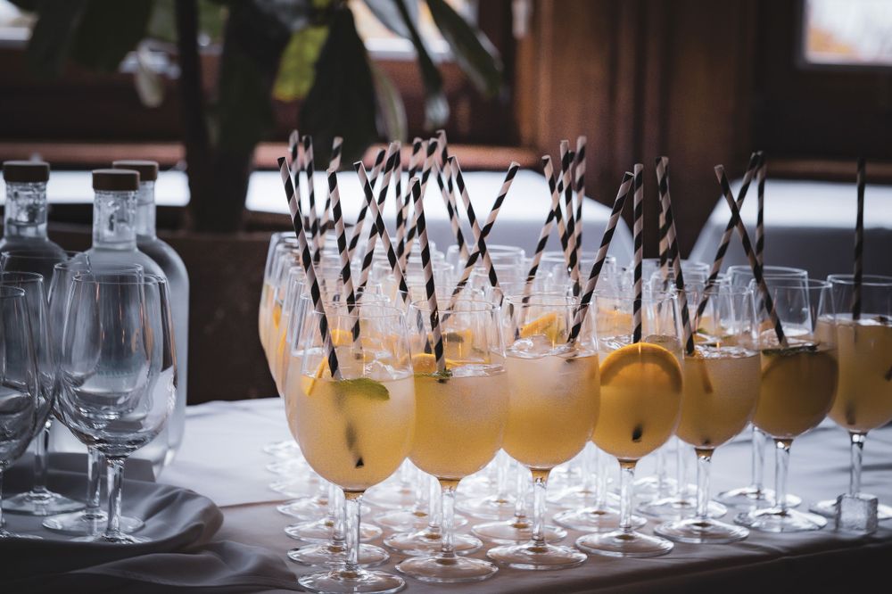 Reihe von Champagner-Cocktails mit schwarzen Strohhalmen, die bei der Veranstaltung serviert wurden.