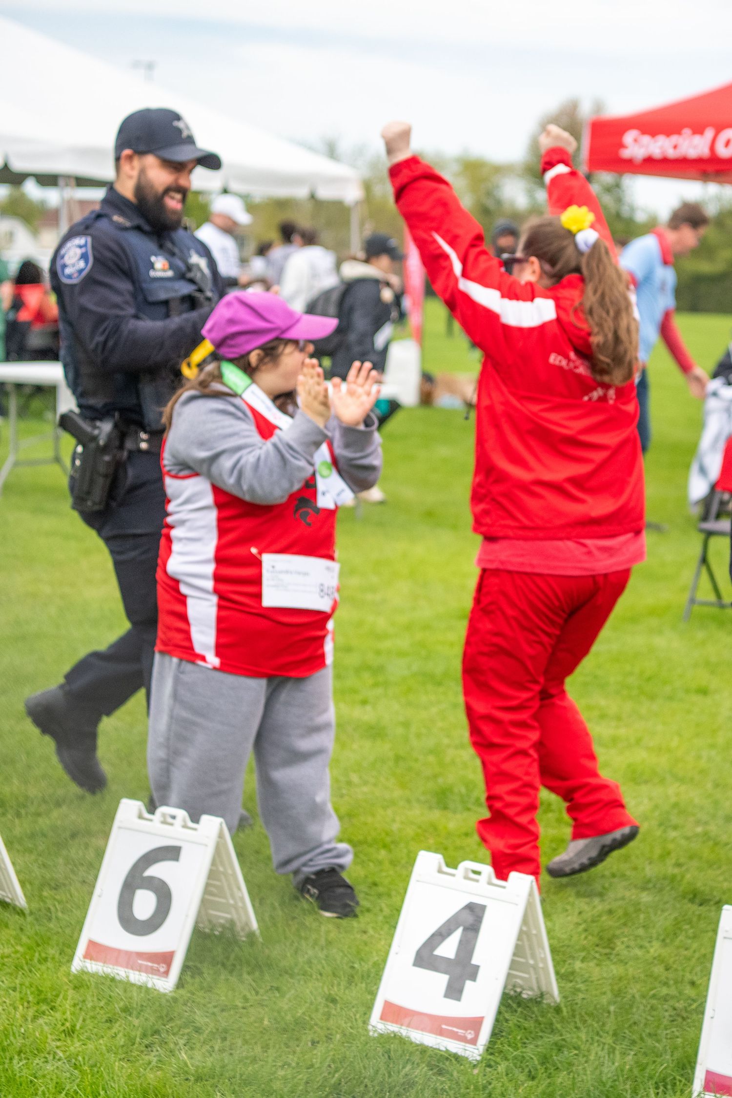 Athletes in red and gray uniforms performing during Special Olympics competition.