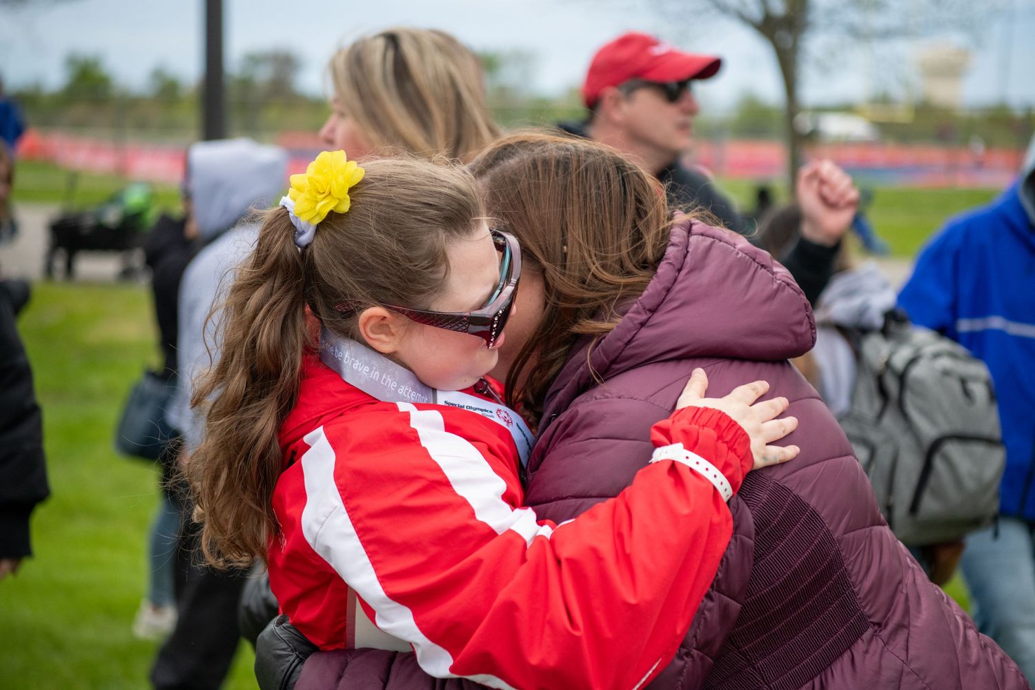 Participants and supporters embracing at Special Olympics event.