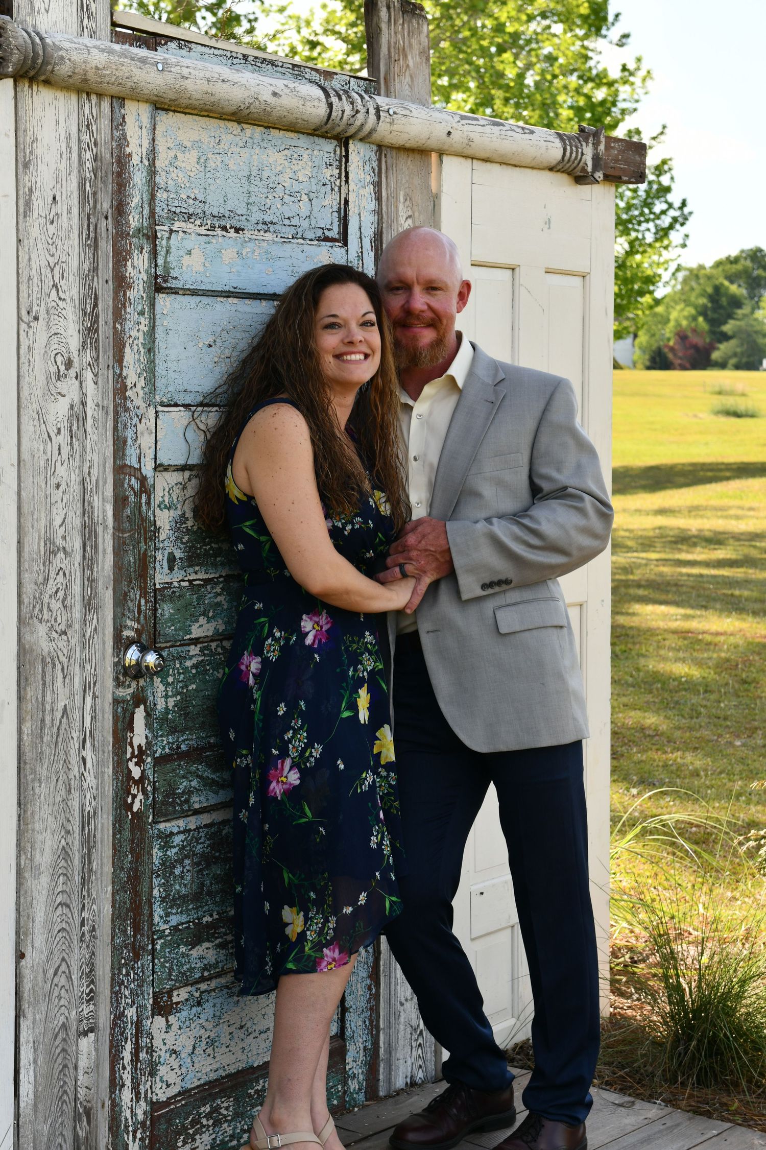 Couples portrait in front of painted doors in field