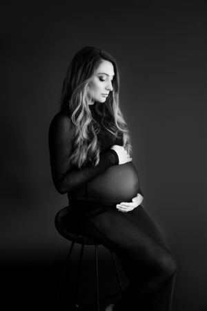 Moody black and white portrait series captured against dark studio backdrop.