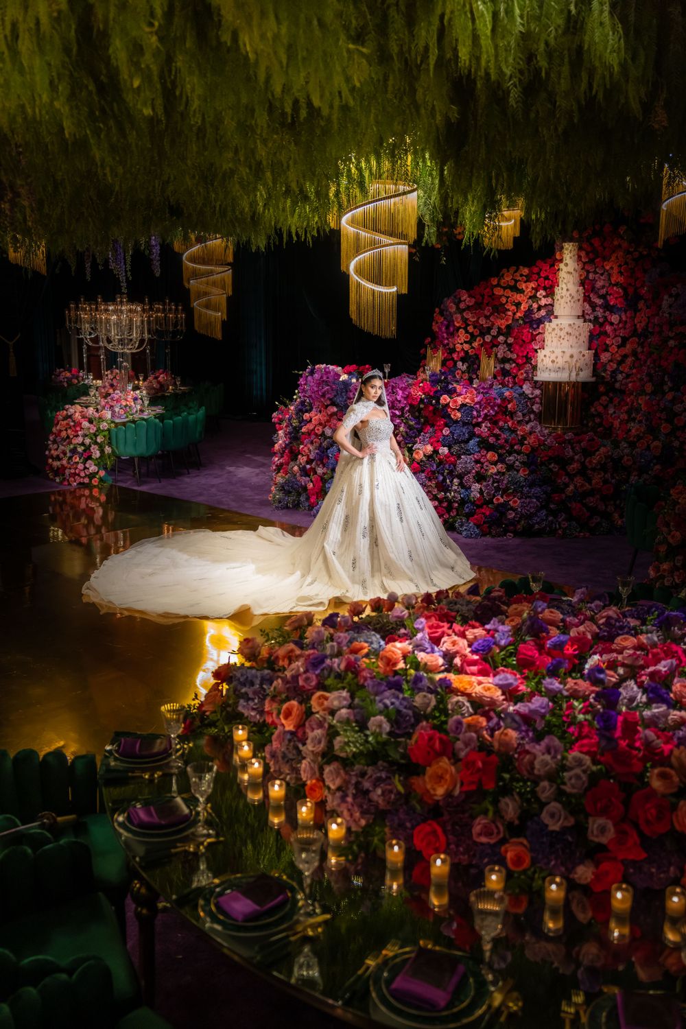 Dramatic wedding dress photo with colorful floral backdrop and candlelit table settings.