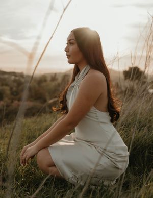 Ethereal sunset portrait in white dress amidst wild grasses for graduation and senior photos in Orange County