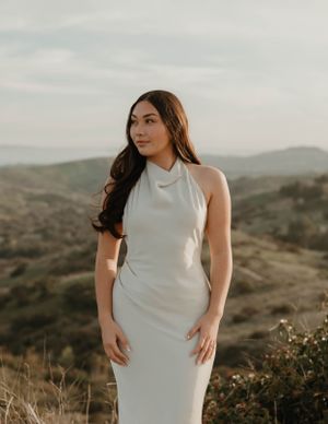 Classic white halter dress portrait against rolling hills at golden hour for graduation and senior photos in Orange County