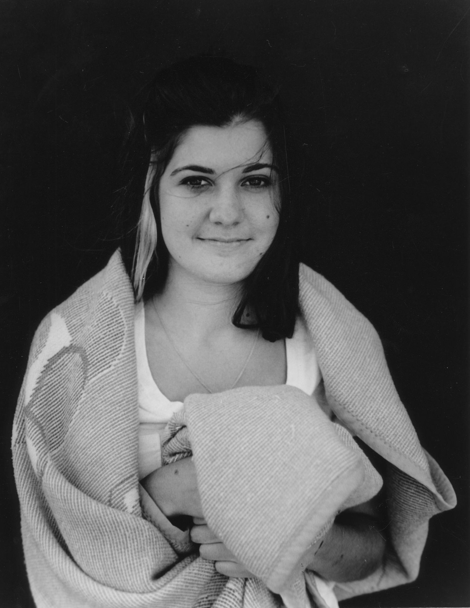 young adult female hugging blanket