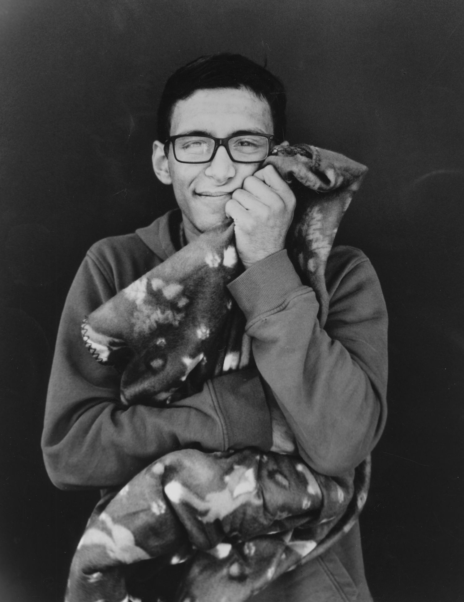 young adult male hugging blanket