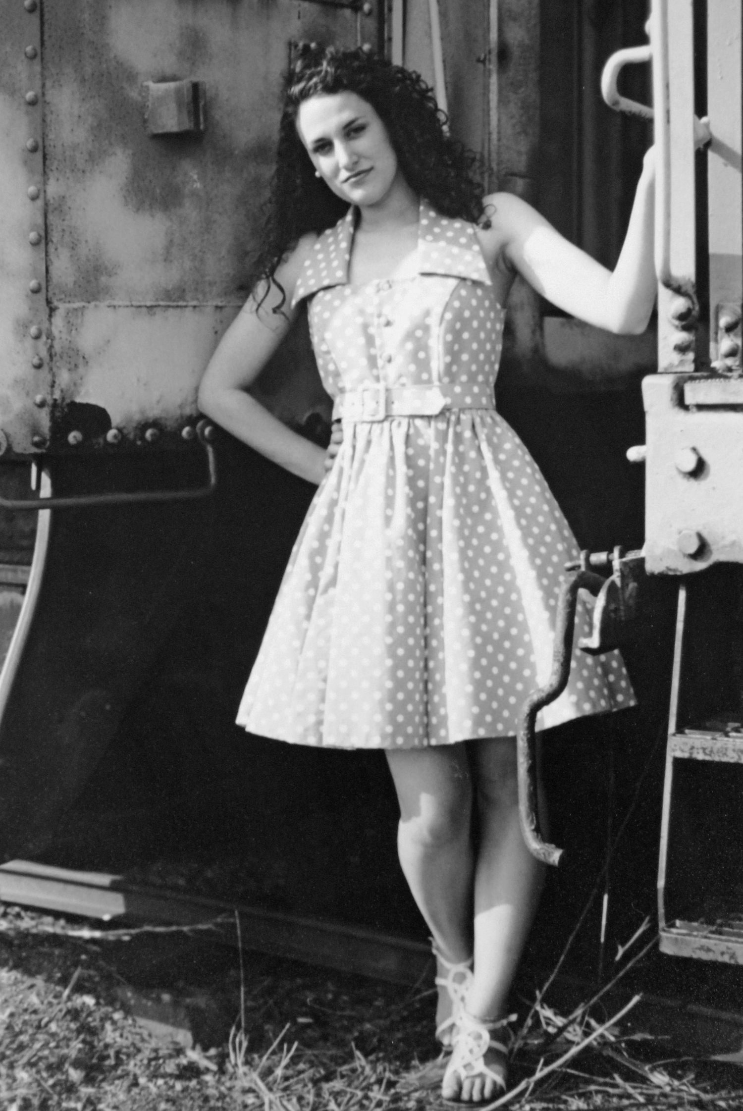 young woman in retro dress leans against steampunk background
