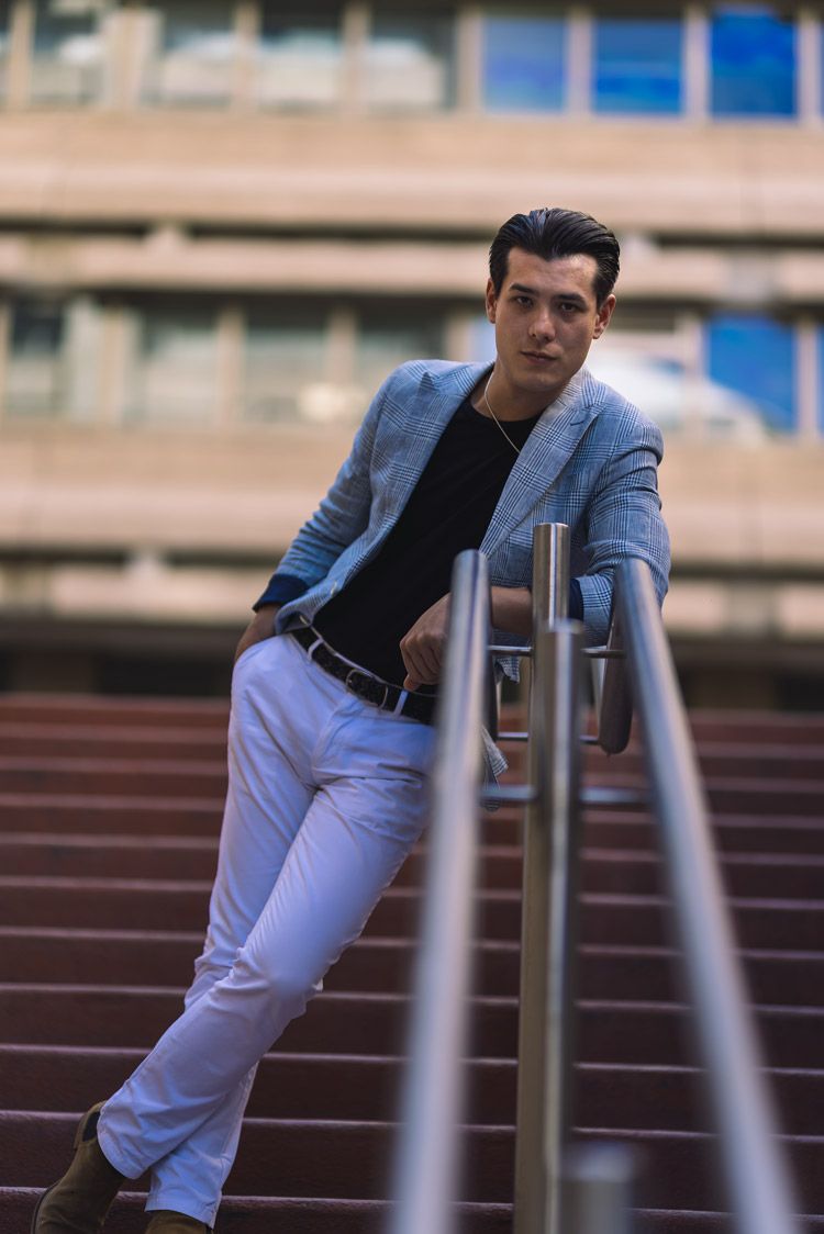 Portrait by Nick Wigmore Photography: man in white pants and blue jacket leaning against railing.