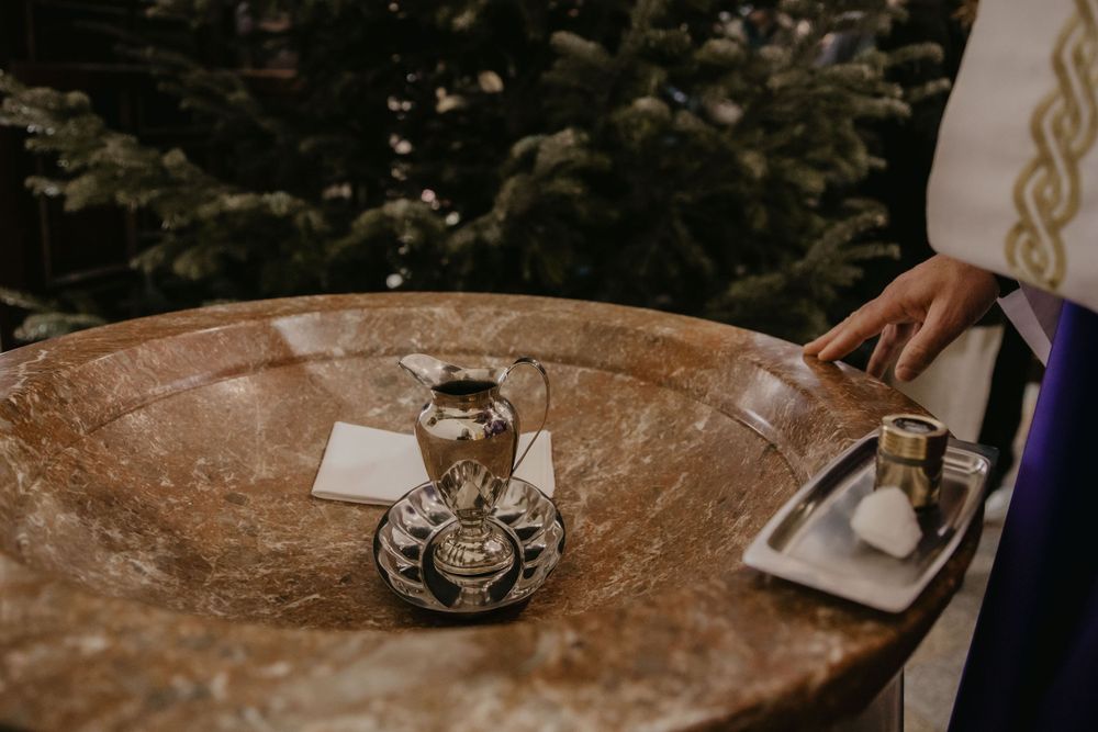 Ornate silver vessels and ceremonial items on a marble surface during a religious ritual.