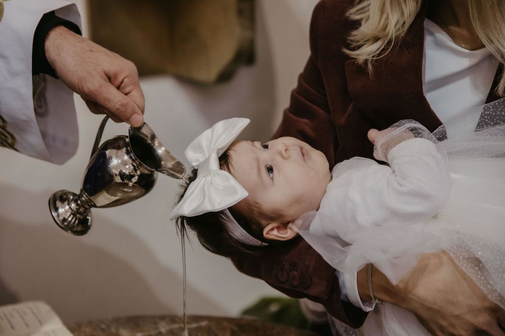 Holy water being poured during a traditional baptism ceremony.