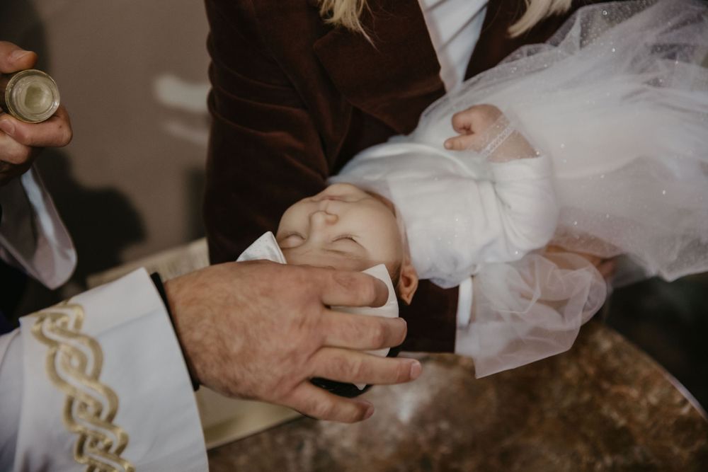 Close-up of hands performing a baptismal blessing with holy water.