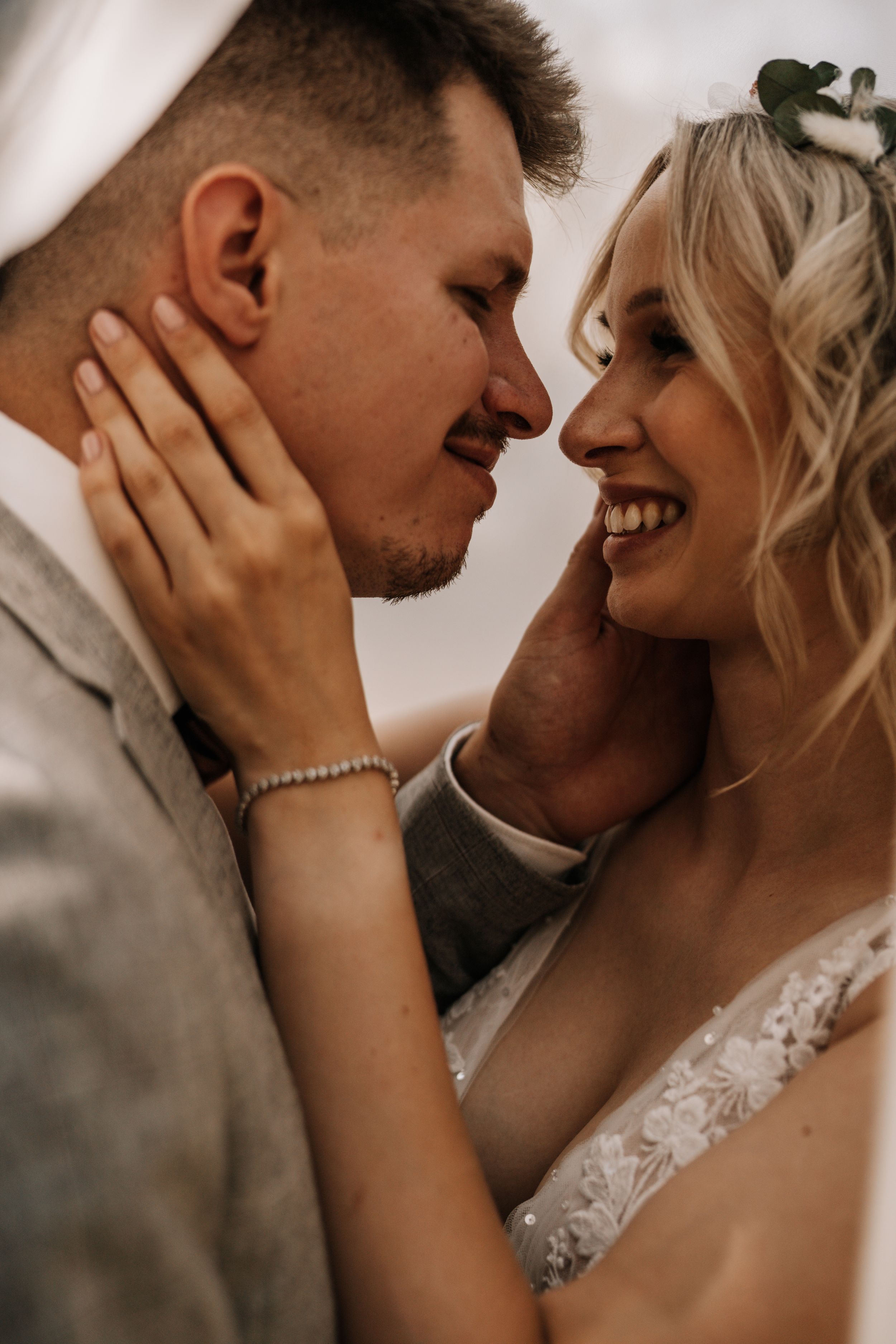 Close-up wedding portrait capturing intimate moment between newlyweds with natural lighting.