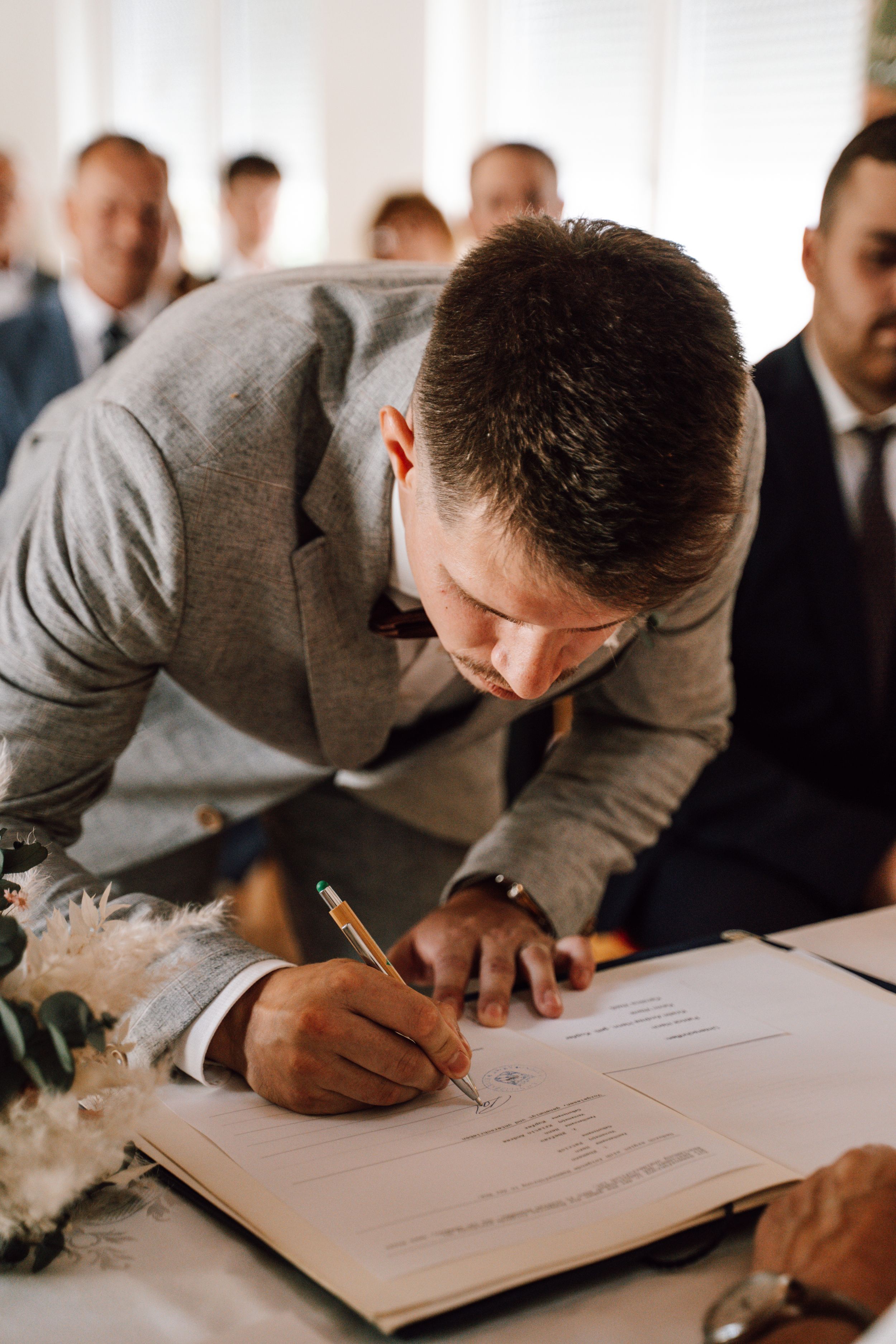 Wedding document signing captured in candid moment during ceremony.