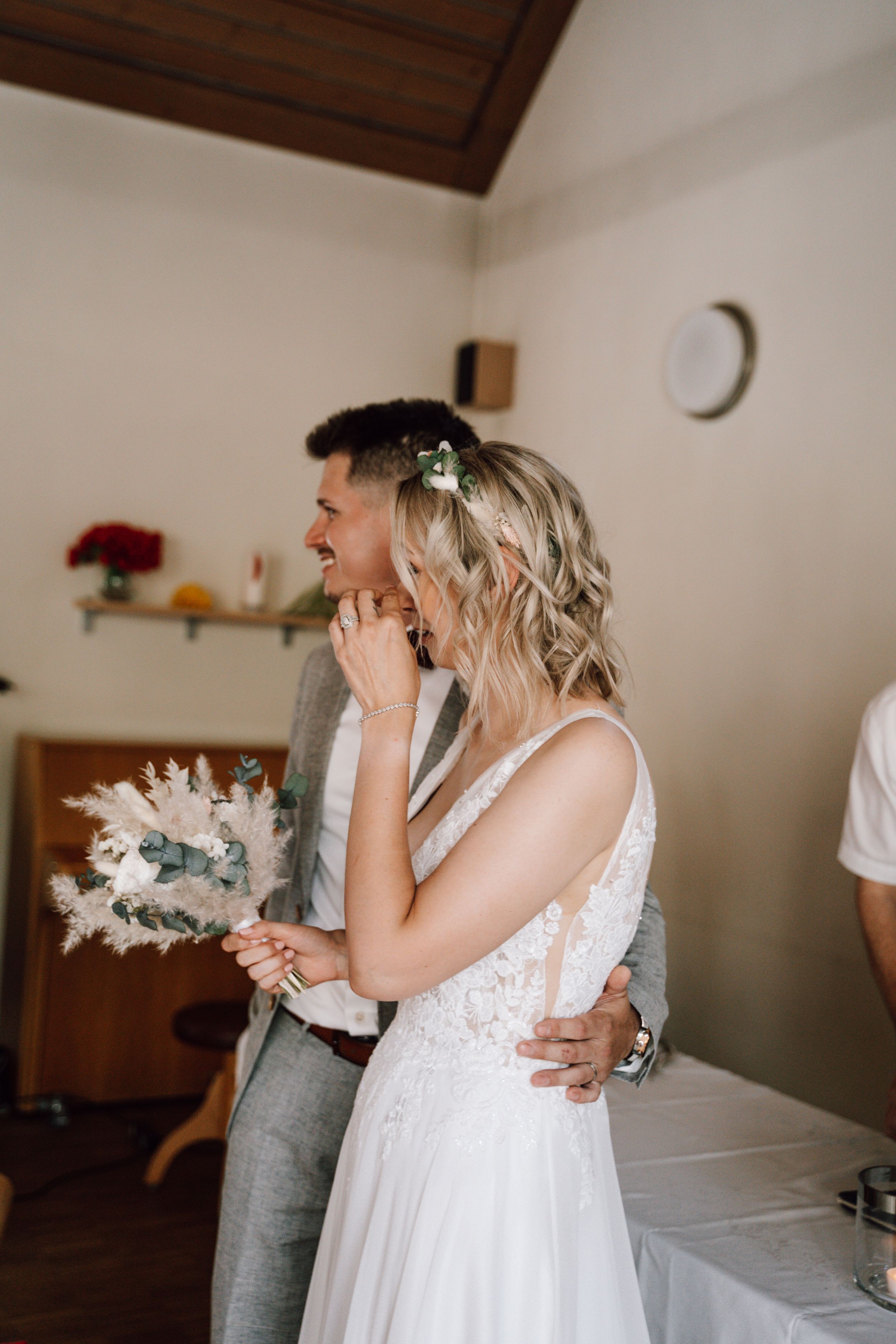 A tender wedding moment showing a couple embracing in an intimate indoor setting.