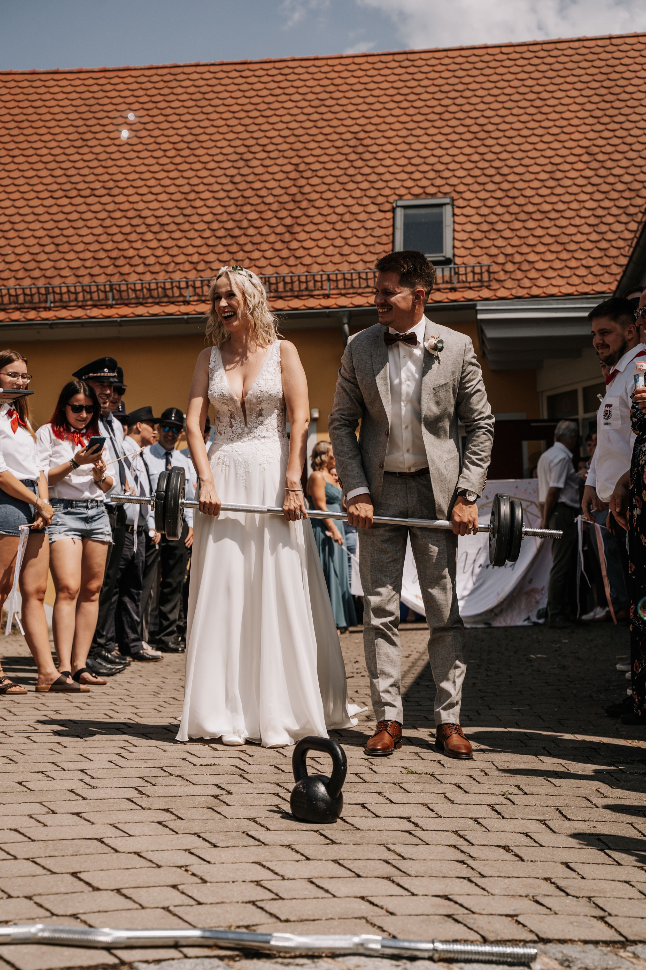 Wedding couple participating in a unique kettlebell ceremony ritual outdoors.