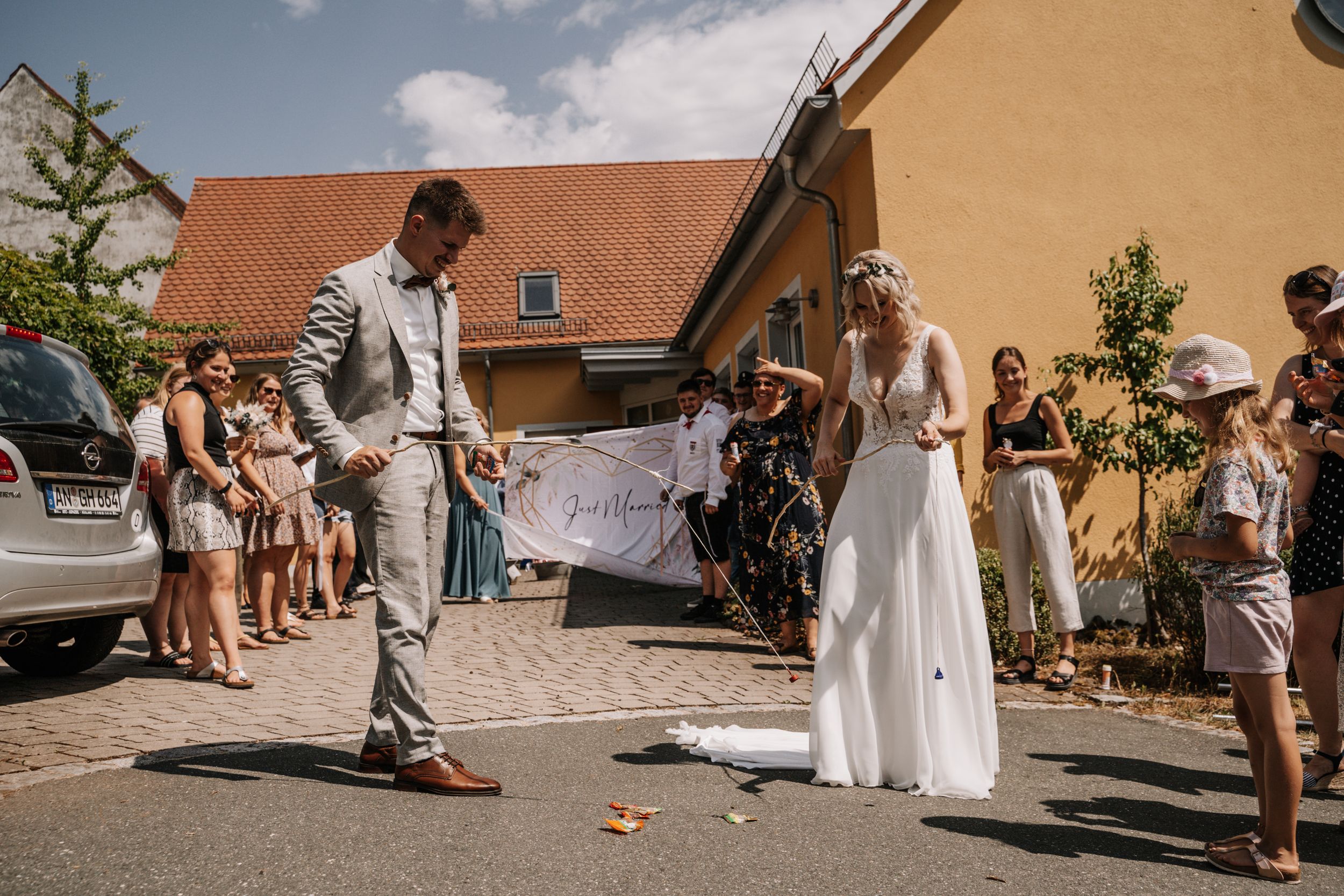 Wedding couple performing a special ceremony ritual outdoors surrounded by guests.