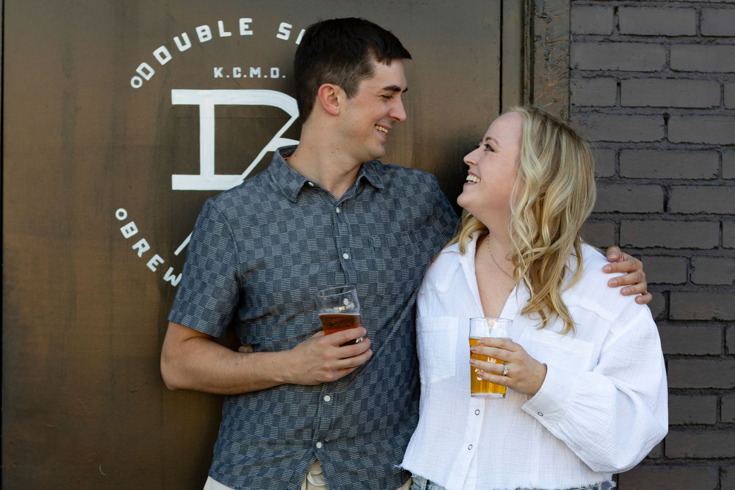 A couple shares a romantic moment while enjoying drinks at a bar.