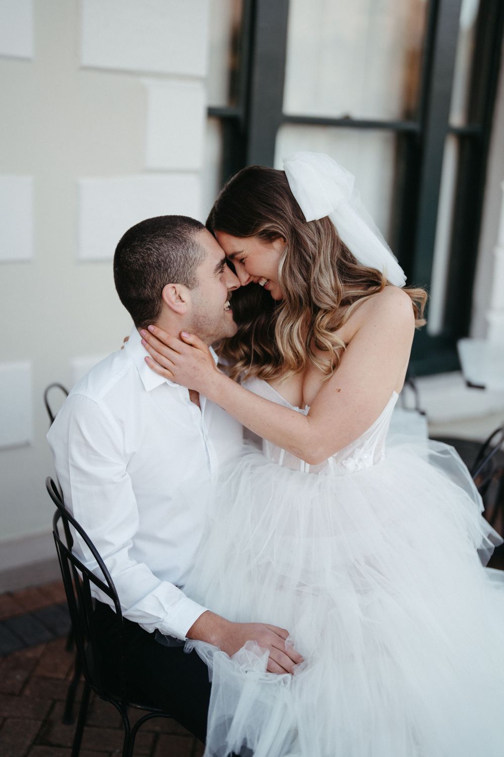 A romantic wedding moment captured as a couple shares an intimate embrace on a chair.